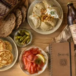 svarog - épicerie fine russe : blinis, saumon fumé, ogorki et kvas sur table